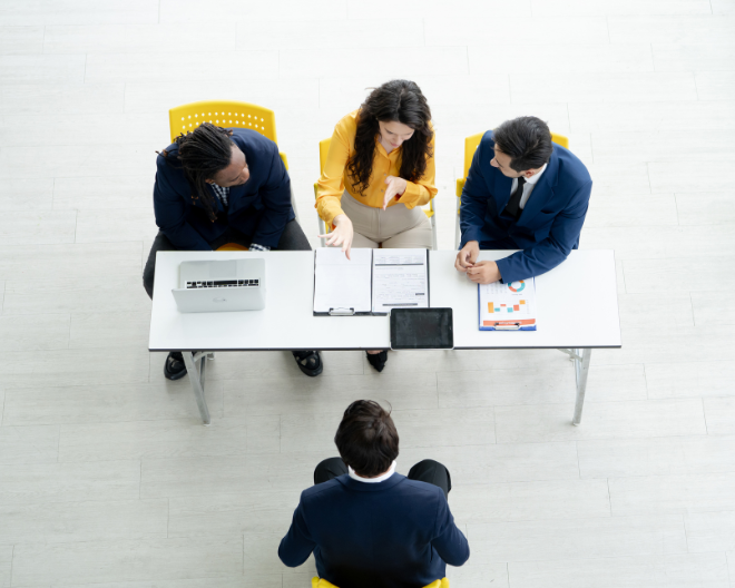 A focused interview setting in Delhi where a candidate faces a panel of decision-makers, emphasizing thorough evaluation and career opportunity.